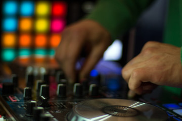 dj hand on controller with selective focus