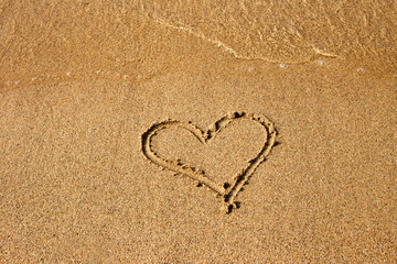 Heart painted at the sand on the summer beach