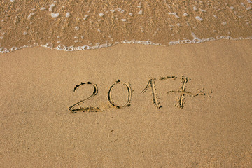 Inscription 2017 at the sand on the summer beach