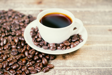 Coffee beans around cup