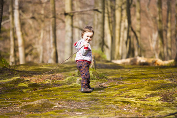 A little boy playing in the woods.