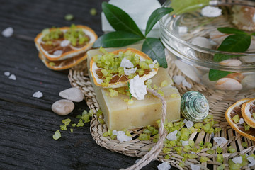 Composition of spa treatment with green salt and soap on wooden