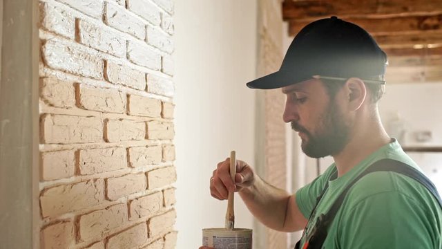 Renovation: man painting a wall, enjoying the work. Slow motion