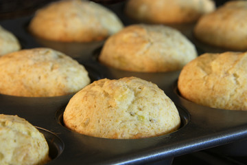 Banana bread muffins baking in a convection oven. Golden brown almost done