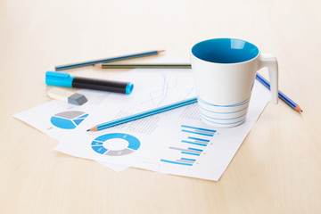 Office workplace with coffee cup and charts