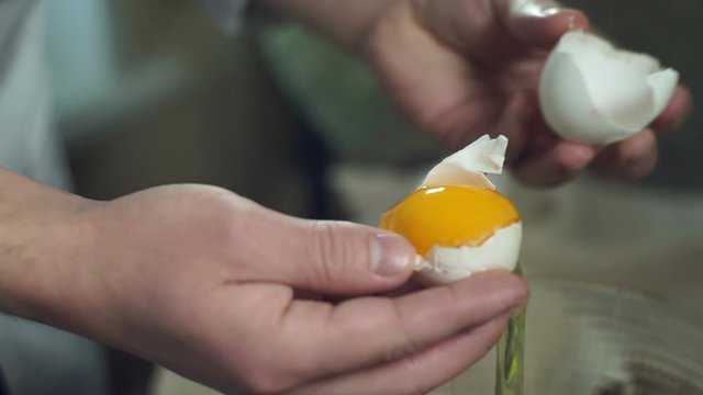 Chef cooking food. Break egg. Closeup. Cooking food. Baking ingredients. Broken eggshell. Preparing food ingredients for baking cake. Chef hands separating yolk from protein