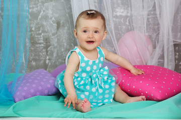 Smiling baby girl is wearing blue dress