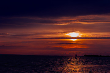 windsurfer against a sunset background at the sea