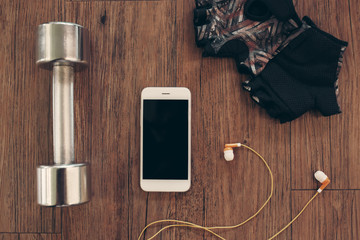 Fitness equipment accesories on wooden background, view above