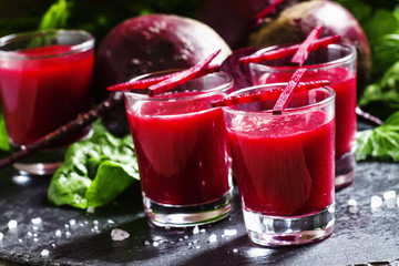 Beet smoothie in glasses, dark background, selective focus