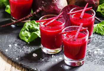 Beet smoothie in glasses, dark background, selective focus