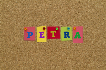 Petra written on colorful notes pinned on cork board. 