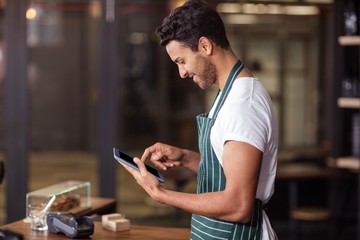 Smiling barista using tablet