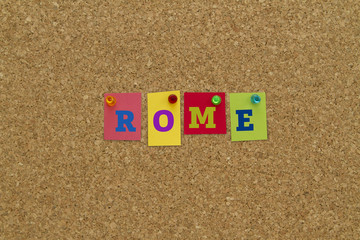 Rome written on colorful notes pinned on cork board. 