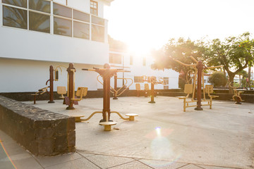 Public playground with outdoor fitness machines - 108995723