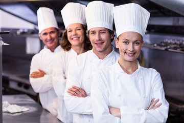 Happy chefs team standing together in commercial kitchen