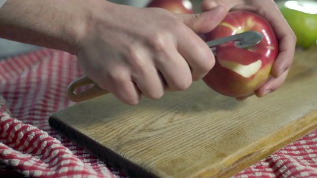 Process cutting peel of fresh apple. Preparing diet food. Hands cut peel apple. Ingredients to baking apple cake. Peeling apples with special knife for peeling fruits. Vegetarian food