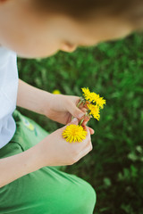 kucający chłopiec trzyma kwiaty