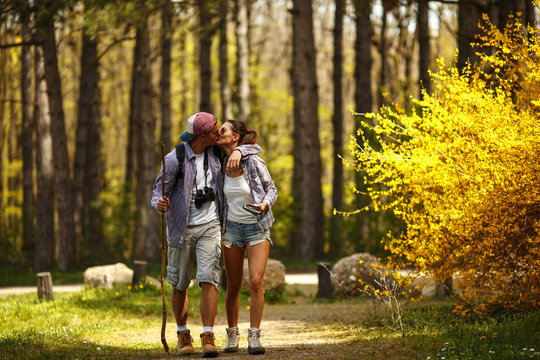 Young couple hiking in nature on beautiful summer day.Young man kissing his girlfriend.