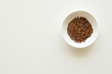 High angle view of flaxseeds in white dish on white table