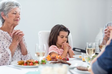 Family praying together before meal