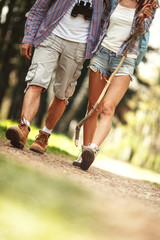 Obraz premium Young couple hiking in nature on beautiful summer day.Only legs are visible.
