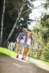 Obraz premium Young couple hiking in nature on beautiful summer day.
