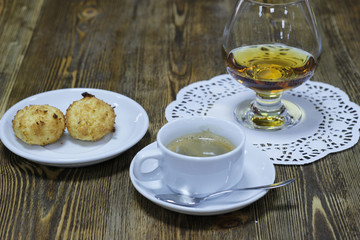 A Cup of hot coffee with biscuits and brandy