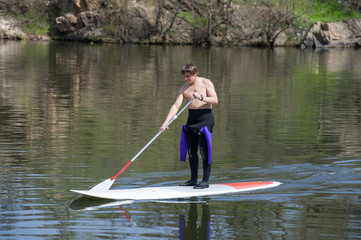 Fototapeta na wymiar athletic man stand up paddle board SUP