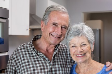 Elderly man and woman standing in kitchen