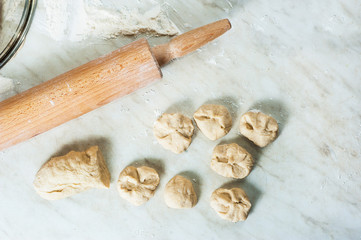 Pieces of dough and rolling pin.