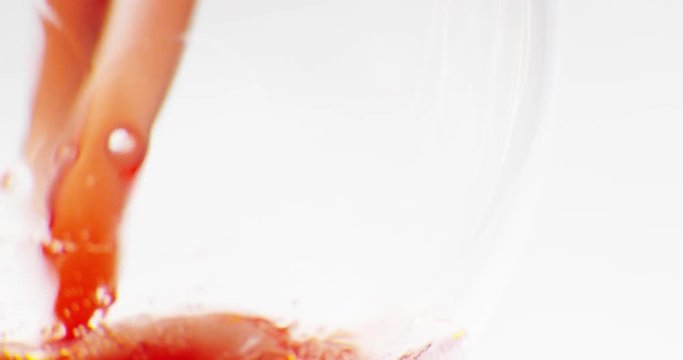 Red wine poured into glass. Close-up, macro shot.