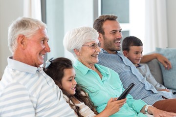 Obraz premium Happy family sitting on sofa