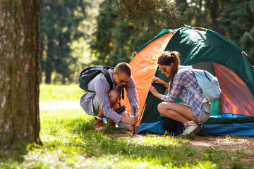 Jeunes campeurs installant la tente dans la forêt.