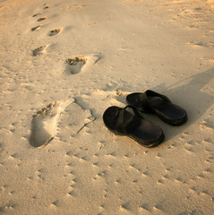 Fototapeta na wymiar Footsteps and Sandal on sand