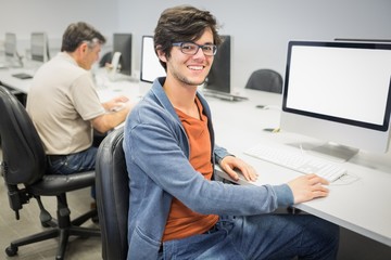Fototapeta na wymiar Portrait of happy student using computer