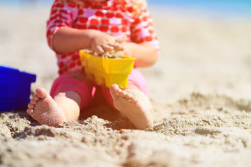 little girl play with toys on beach