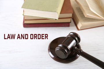 Gavel with books on wooden table closeup. Law and order concept