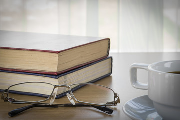 Book and Eyeglasses on a wood table