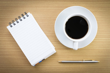 Coffee and notepad on wood table