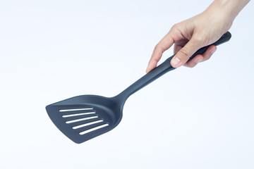 Black plastic kitchen spatula on white background