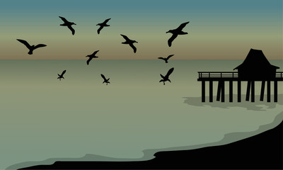 silhouette of huts and bird at the beach