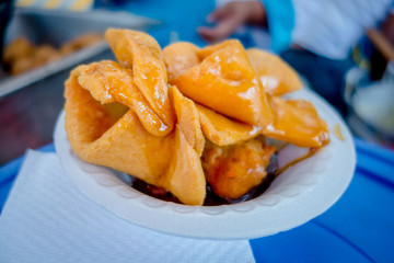 Bunuelos close up, traditional ecuadorian dessert served with honey and brown sugar