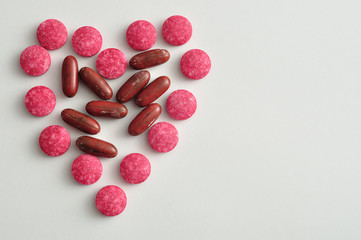 Pills packed in the shape of a heart displayed on a white background