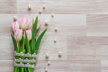 Bouquet of pink tulips with lace on a wooden background and empt