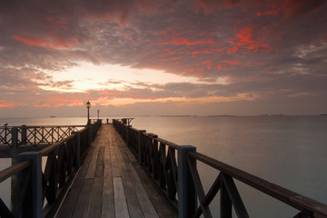 Fototapeta na wymiar Long pier overlooking the sea during sunrise 