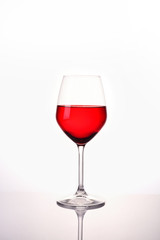 Red water in wine glass on white background