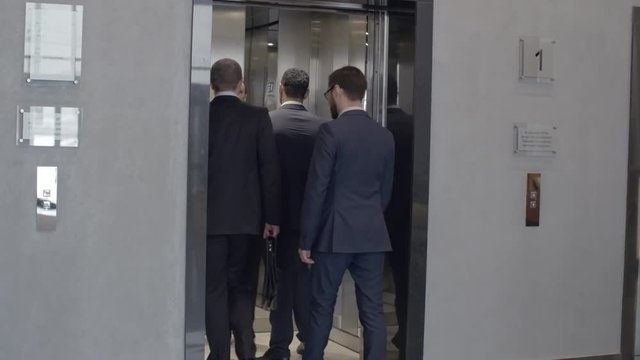 Group of business people waiting for elevator on the first floor, entering it and moving up