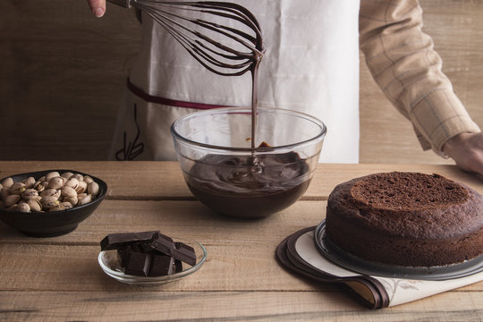 Woman cooking chocolate cake with ganache and pistachios
