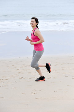 Fitness woman jogging on the beach
